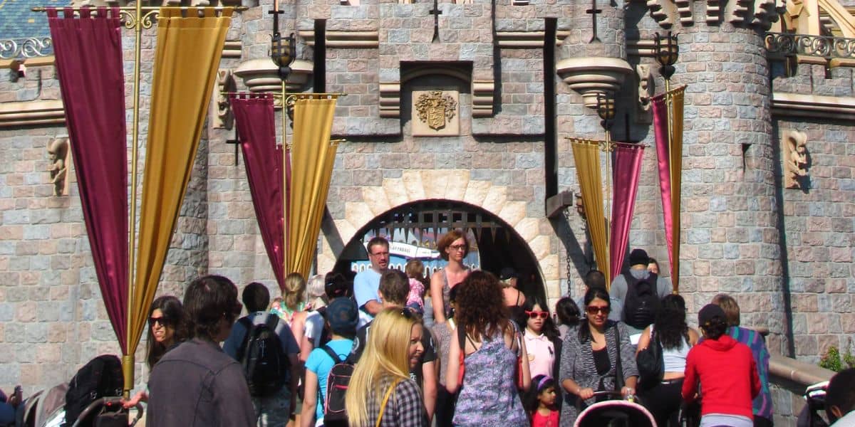 Guests walking through Sleeping Beauty Castle at Disneyland.