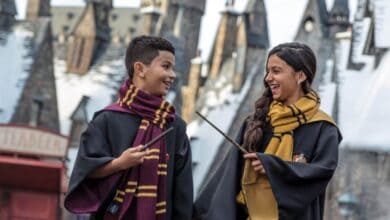 Guests in wizard robes with wands in Hogsmeade at Universal Orlando's Wizarding World of Harry Potter. Universal Orlando crowds.