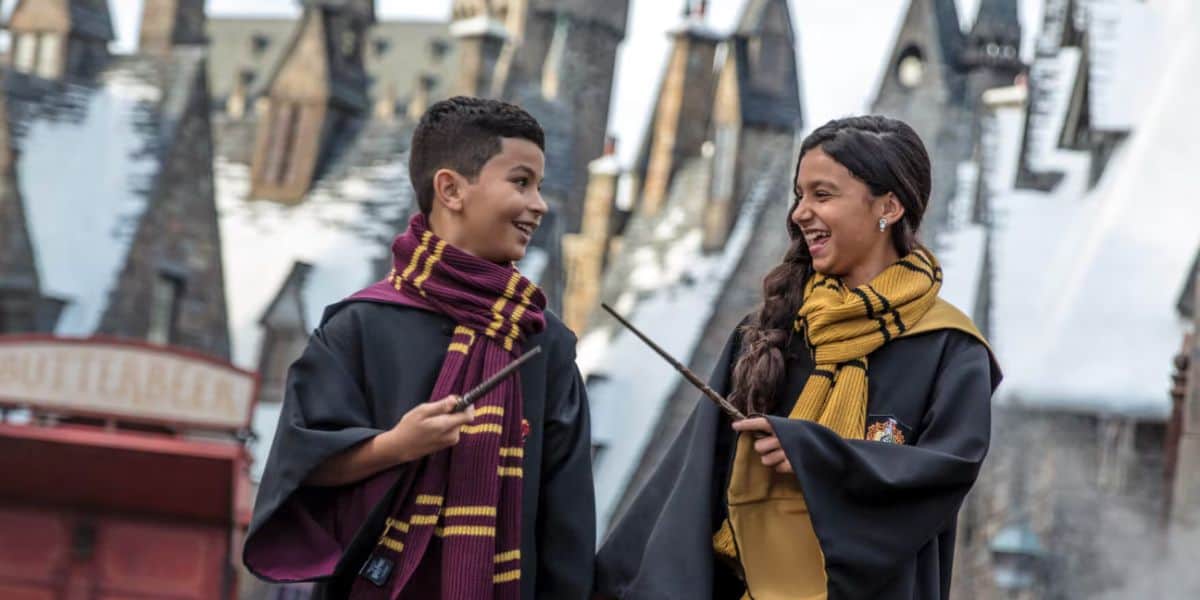 Guests in wizard robes with wands in Hogsmeade at Universal Orlando's Wizarding World of Harry Potter. Universal Orlando crowds.