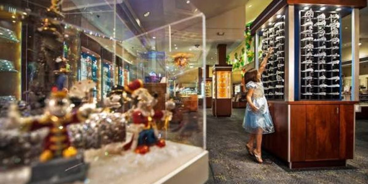 A girl reaches for a tiara inside Crystal Arts by Arribas Brothers