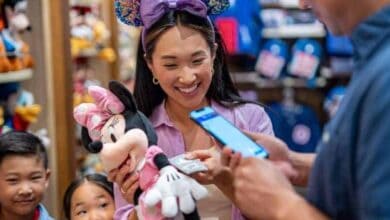 A Disneyland or Disney World cast member taking mobile payment for merchandise.