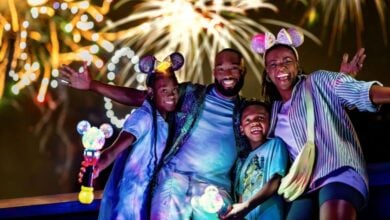 disney world family poses in front of fireworks