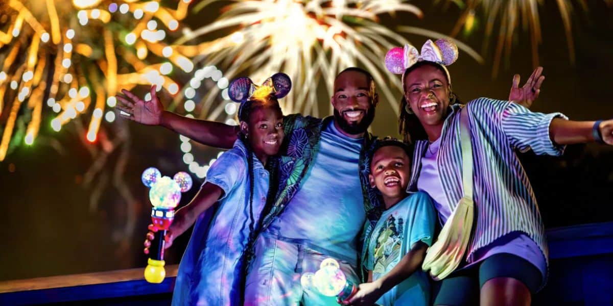 disney world family poses in front of fireworks