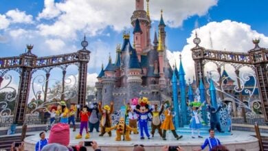 mickey and friends perform with castle in the background in disneyland paris