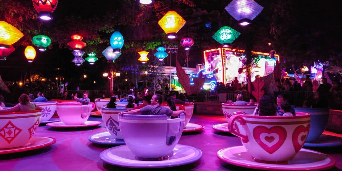 Guests spin in the Mad Tea Party teacups at Disneyland Park at night