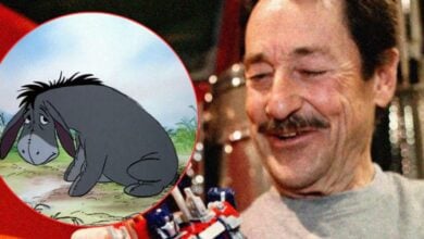 A guest beams while showing off a plush toy, with Eeyore from Winnie the Pooh featured in a circular frame.