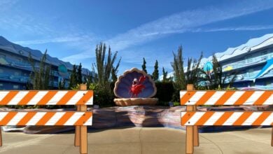 Sebastian the crab sculpture nestled in a shell with orange construction barriers out front, displayed outdoors at Disney’s Art of Animation Resort. The whimsical setup signals exciting refurbishments coming to this beloved Disney destination in 2027.