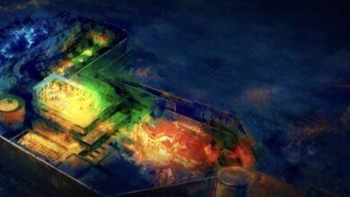 Bird’s-eye view of a sunken pirate ship at SeaWorld’s underwater adventure zone, dramatically lit with vibrant blue, green, and orange spotlights.