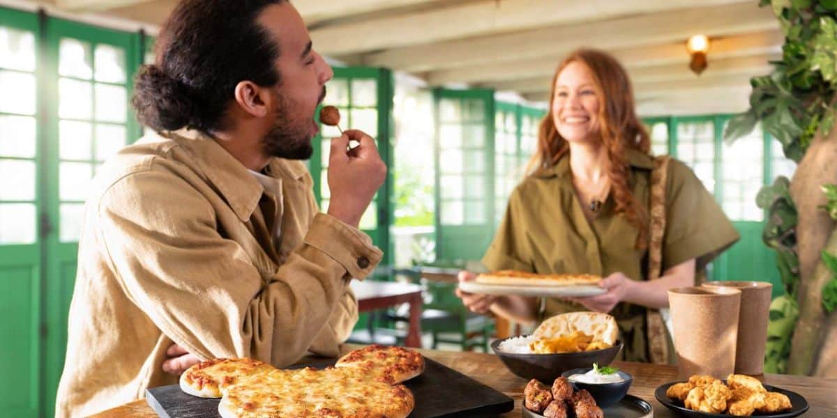 A guest enjoys pizza at Colonel Hathi's