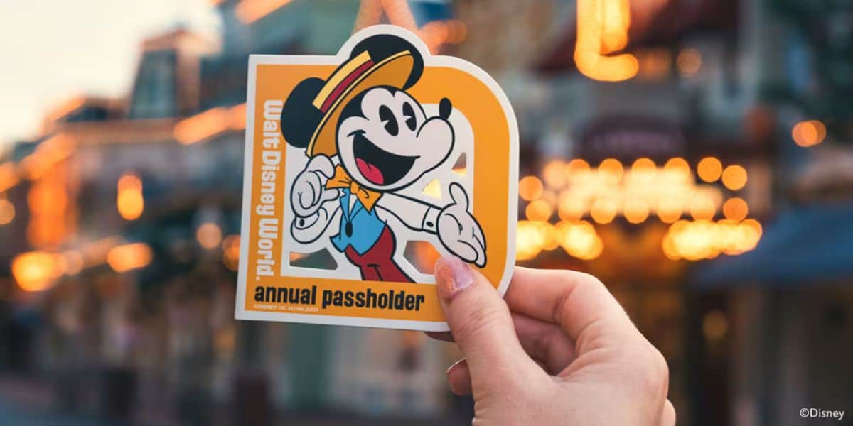 A Disney World Passholder Magnet sticker featuring Mickey Mouse held up against a backdrop of sparkling park lights. Passholder Magnets are limited to two per household.