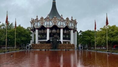 A fountain dyed red at Six Flags Great America sits in front of an audio-animatronic pumpkin and carousel for Fright Fest.