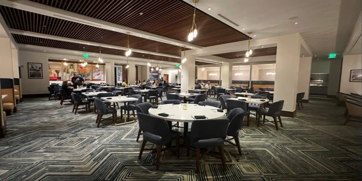 Steakhouse 71’s stylish dining room at Disney’s Contemporary Resort features round tables, sleek blue chairs, and a relaxed vibe with just a few fellow park-goers enjoying their meals—making it an inviting spot to refuel during your Walt Disney World adventure.