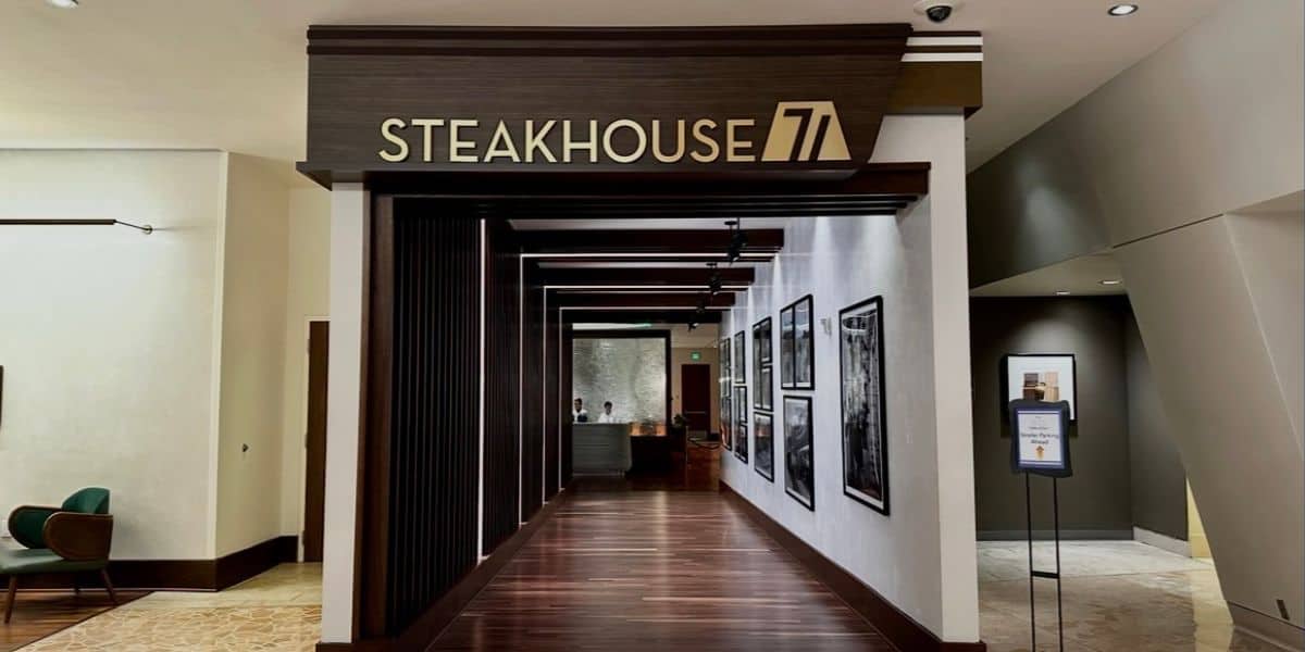 Stepping into Steakhouse 71 at Disney’s Contemporary Resort, you’re greeted by a wall of classic Disney photos on the right, leading to a welcoming hostess stand ready to check in your reservation for a magical dining experience.