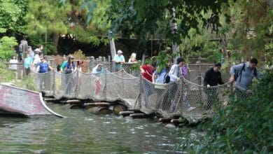 Guests make their way across the barrel bridge on Pirate's Lair on Tom Sawyer Island