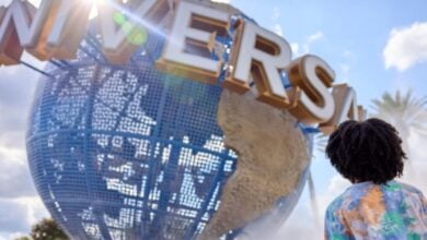 Universal Orlando's iconic spinning globe and a guest standing in front of it