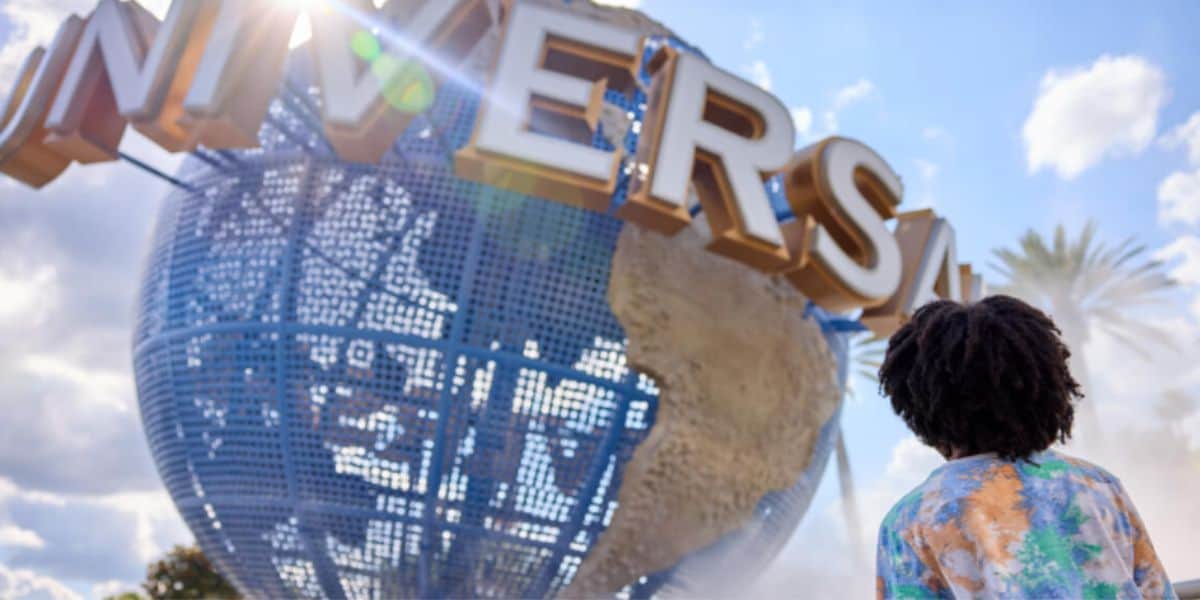 Universal Orlando's iconic spinning globe and a guest standing in front of it