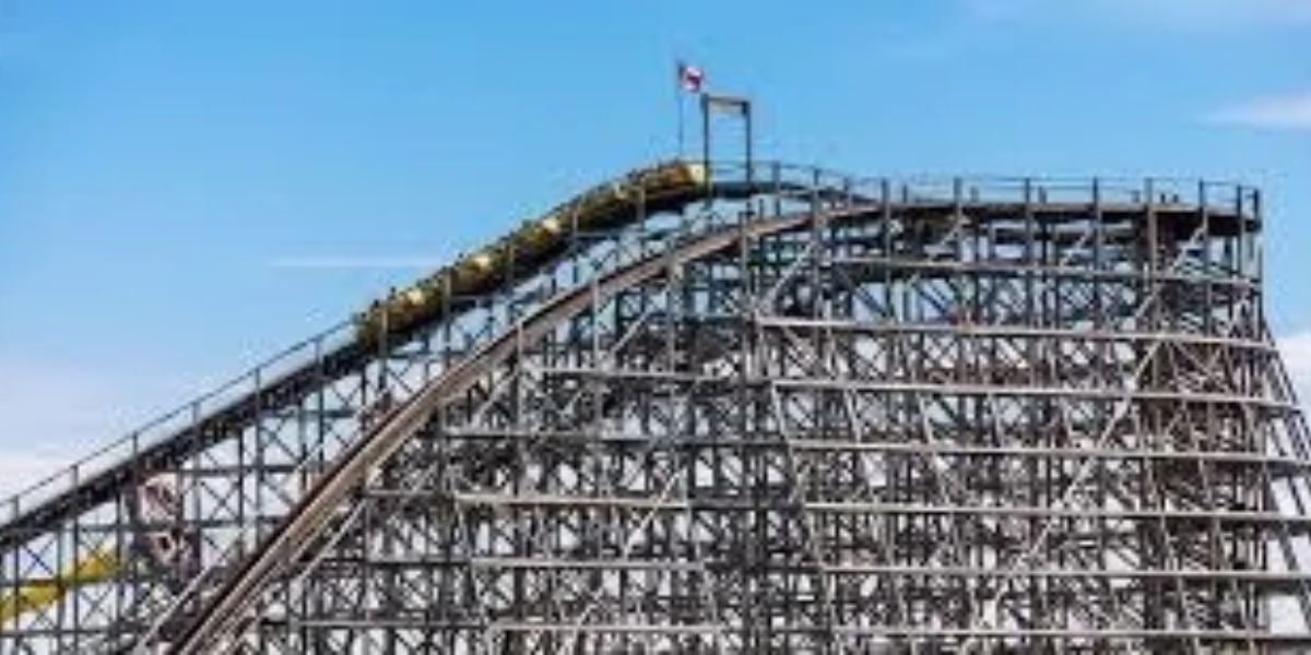 Six Flags wooden roller coaster train cresting the lift hill.