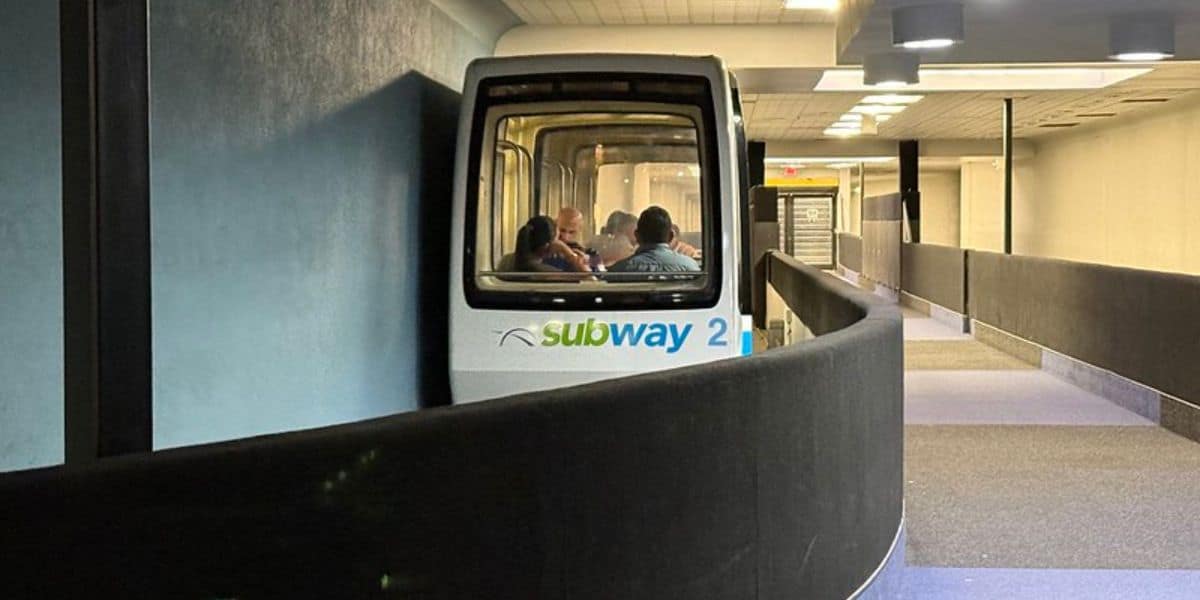 Guests riding in car 2 of the Disneyland PeopleMover through a tunnel.