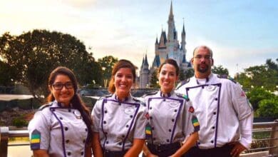 Four Disney culinary Cast Members in front of Cinderella Castle at Magic Kingdom.