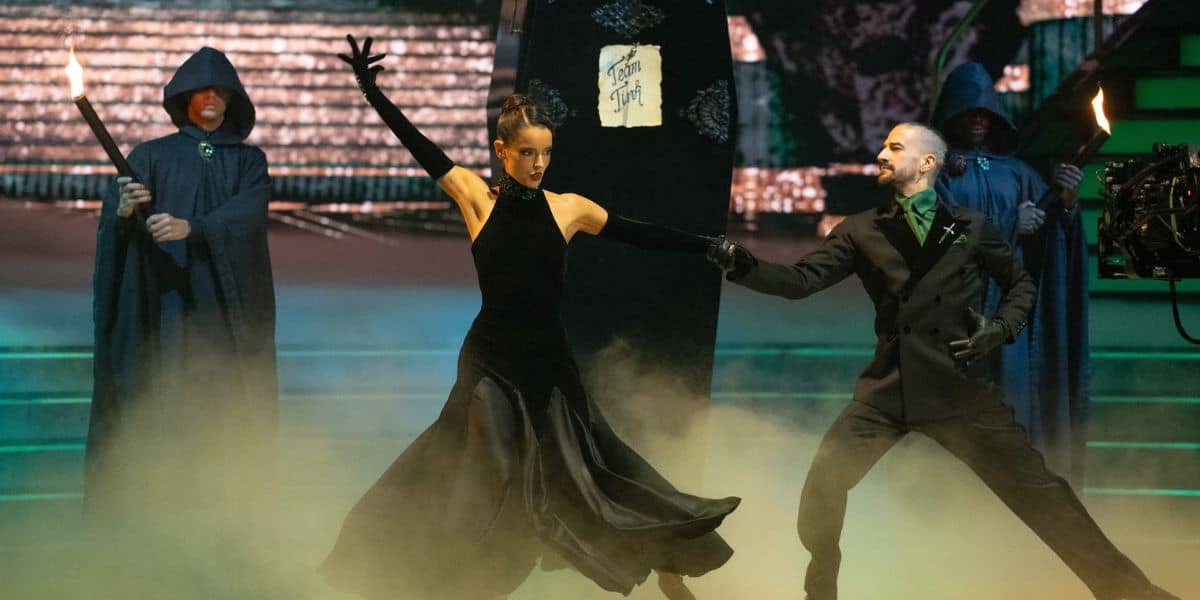 Two dancers perform a spooky routine on the Dancing With the Stars stage featuring a coffin and hooded figures for an elimination episode.