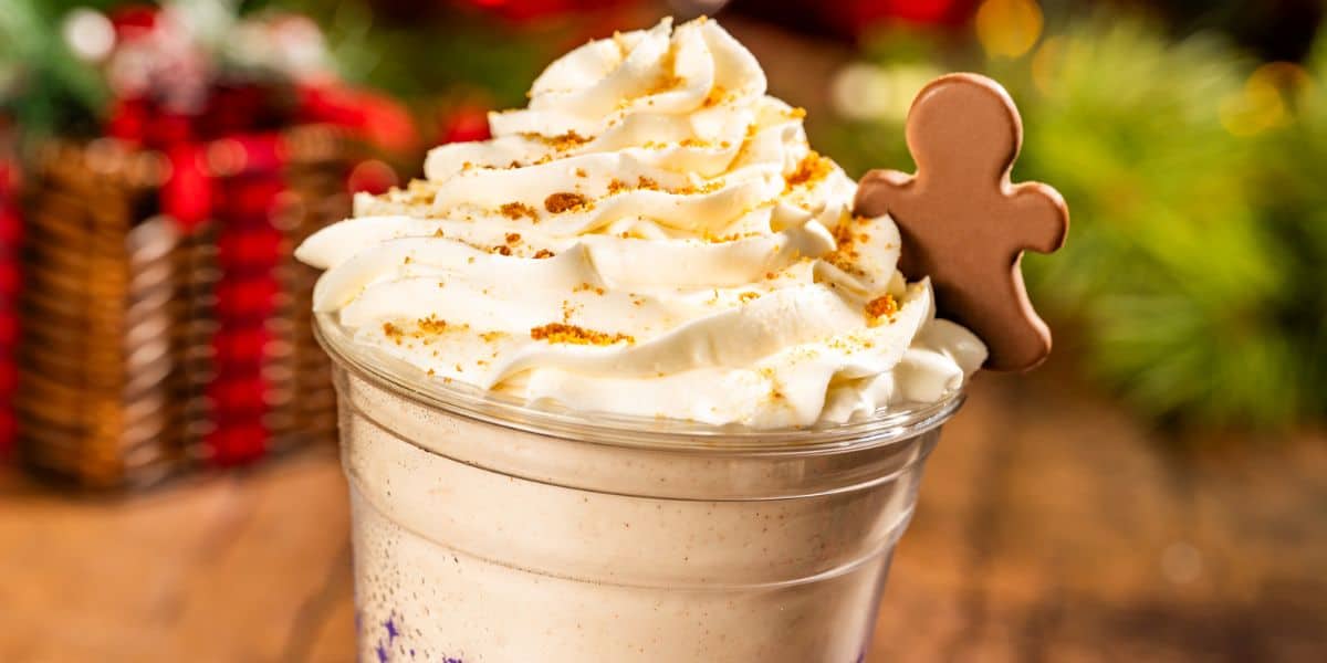 A holiday milkshake topped with whipped cream and a gingerbread man cookie, one of many festive Disney World treats.