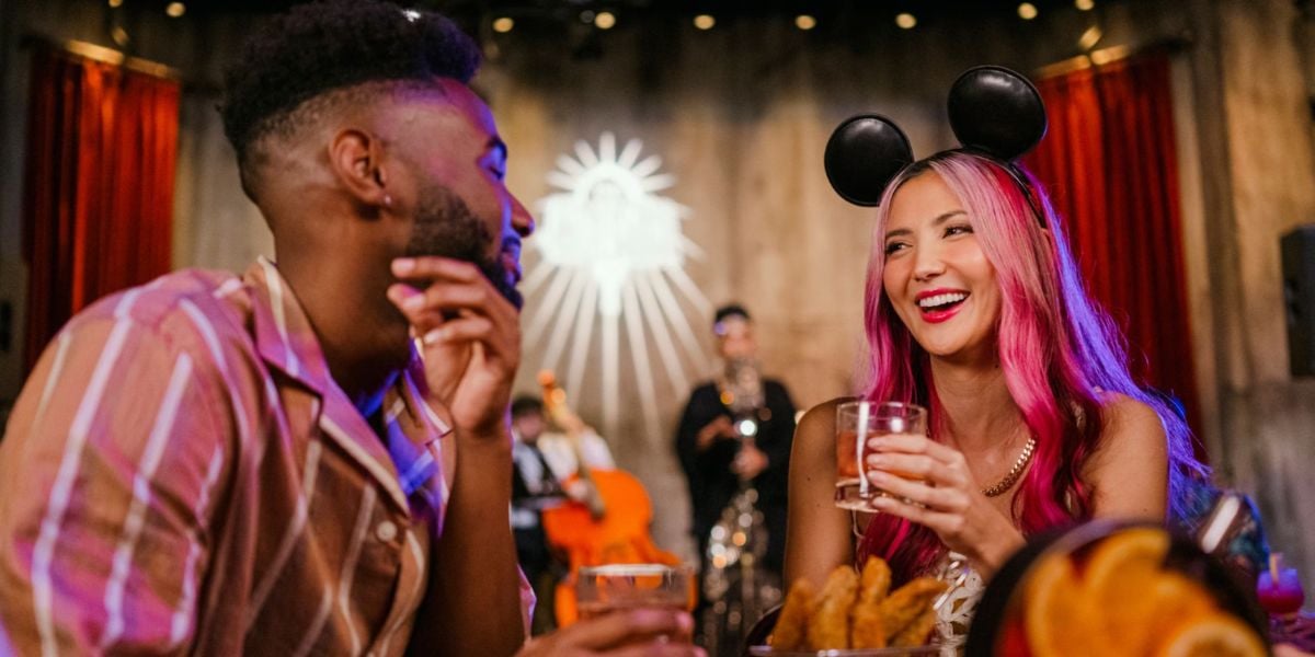 A couple enjoying holiday drinks at Trader Sam’s Grog Grotto, with the woman wearing Minnie ears at Disney’s Polynesian Village Resort.