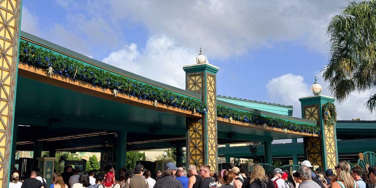 Guests entering Disney’s Hollywood Studios adorned with holiday garlands, contrasting with the festive atmosphere at Epic Universe.