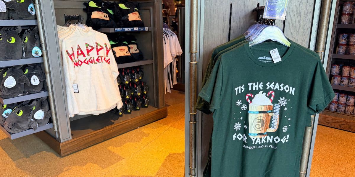 Toothless plushies, a holiday fleece, and Universal Epic Universe holiday t-shirts for sale at a Universal Orlando Resort shop.