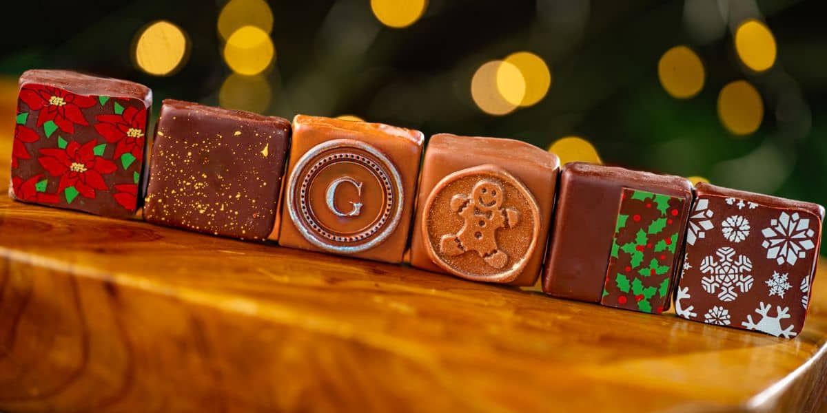 Six holiday-themed chocolate squares from Disney World lined up in a row.