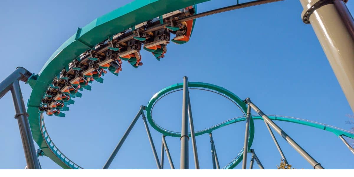 Inverted coaster train carving through a high-speed helix above a massive loop.