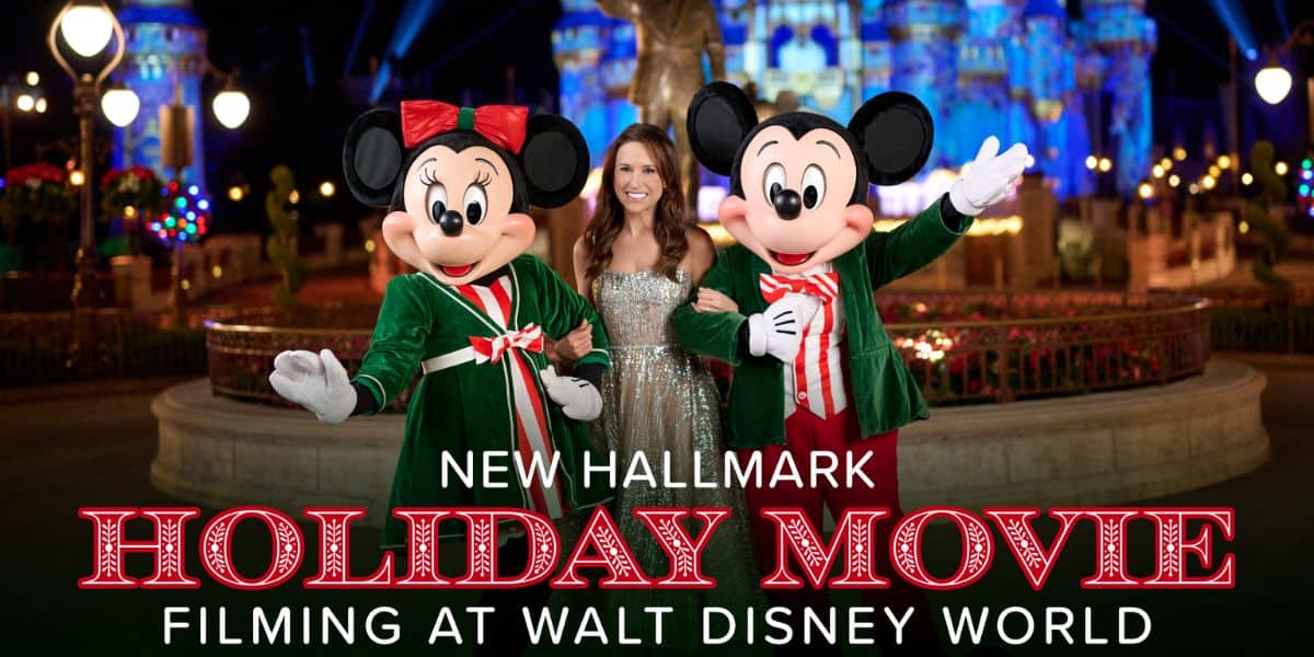 Mickey and Minnie Mouse with a host at Cinderella Castle during a Disney holiday celebration.