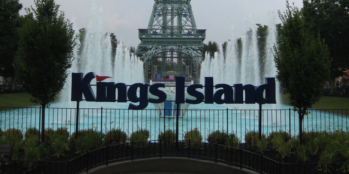 The Kings Island sign with the park’s Eiffel Tower and fountain in the background.