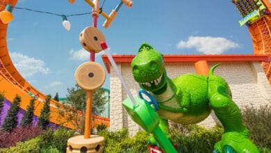 Rex statue plays with a toy controller in Toy Story Land