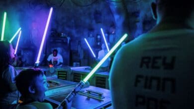 Guests ignite lightsabers during a building experience at Savi’s Workshop in Star Wars: Galaxy’s Edge