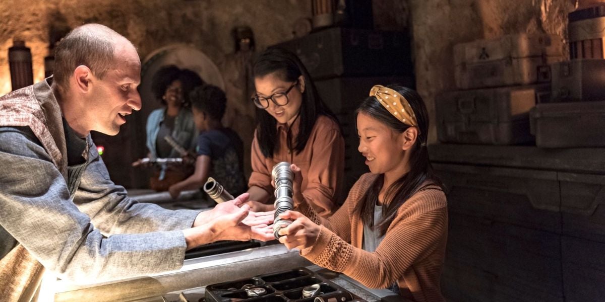 A guest building a custom lightsaber at Savi’s Workshop in Star Wars: Galaxy’s Edge.