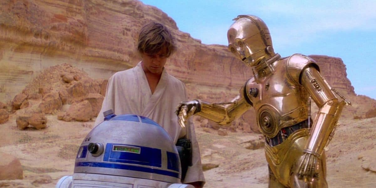 Luke Skywalker, C-3PO, and R2-D2 on Tatooine in Star Wars: A New Hope