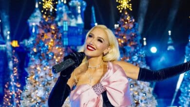 Gwen Stefani performing on stage in front of Sleeping Beauty Castle at Disneyland.